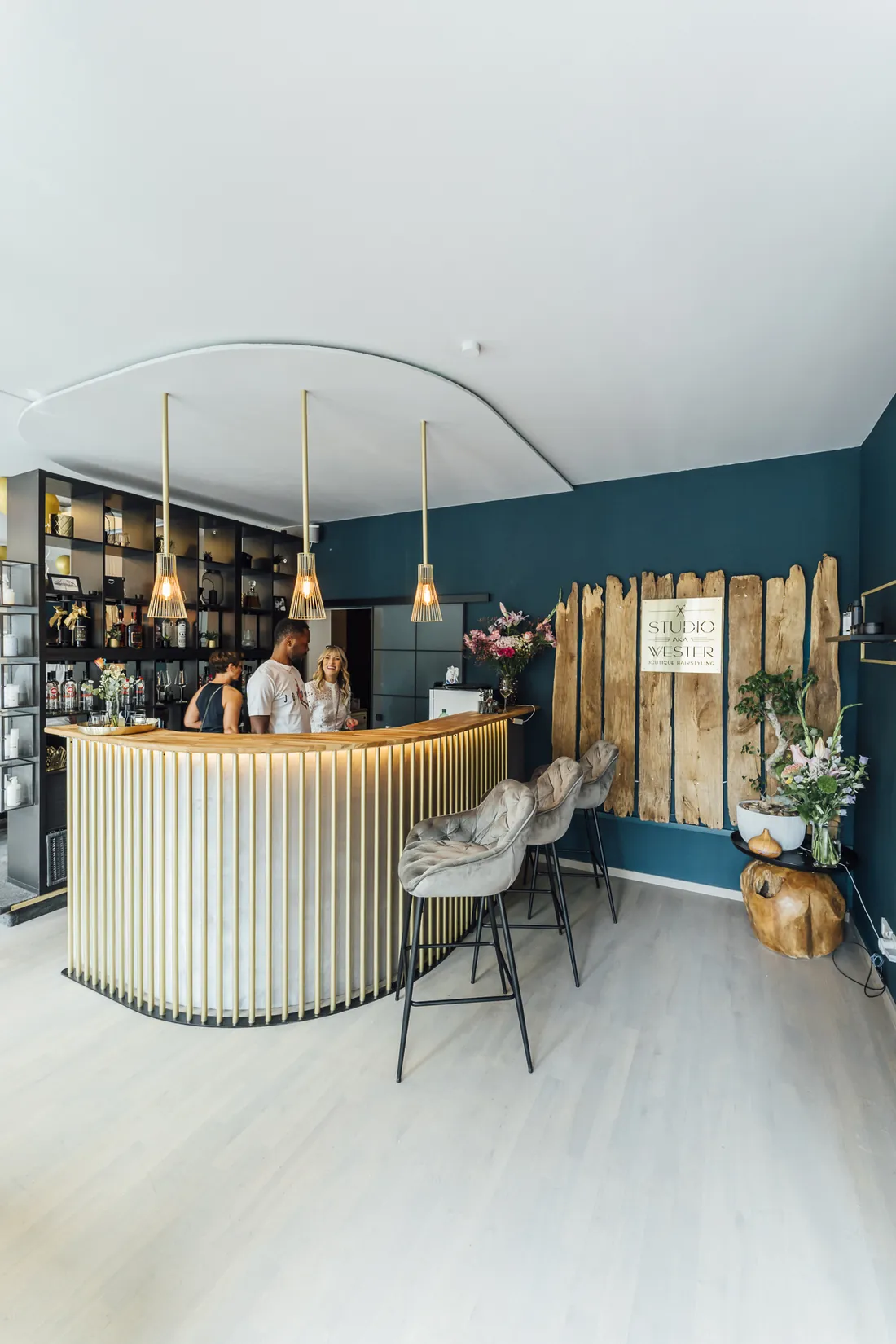 Salon-Café mit goldener Bar vor petrolfarbener Wand