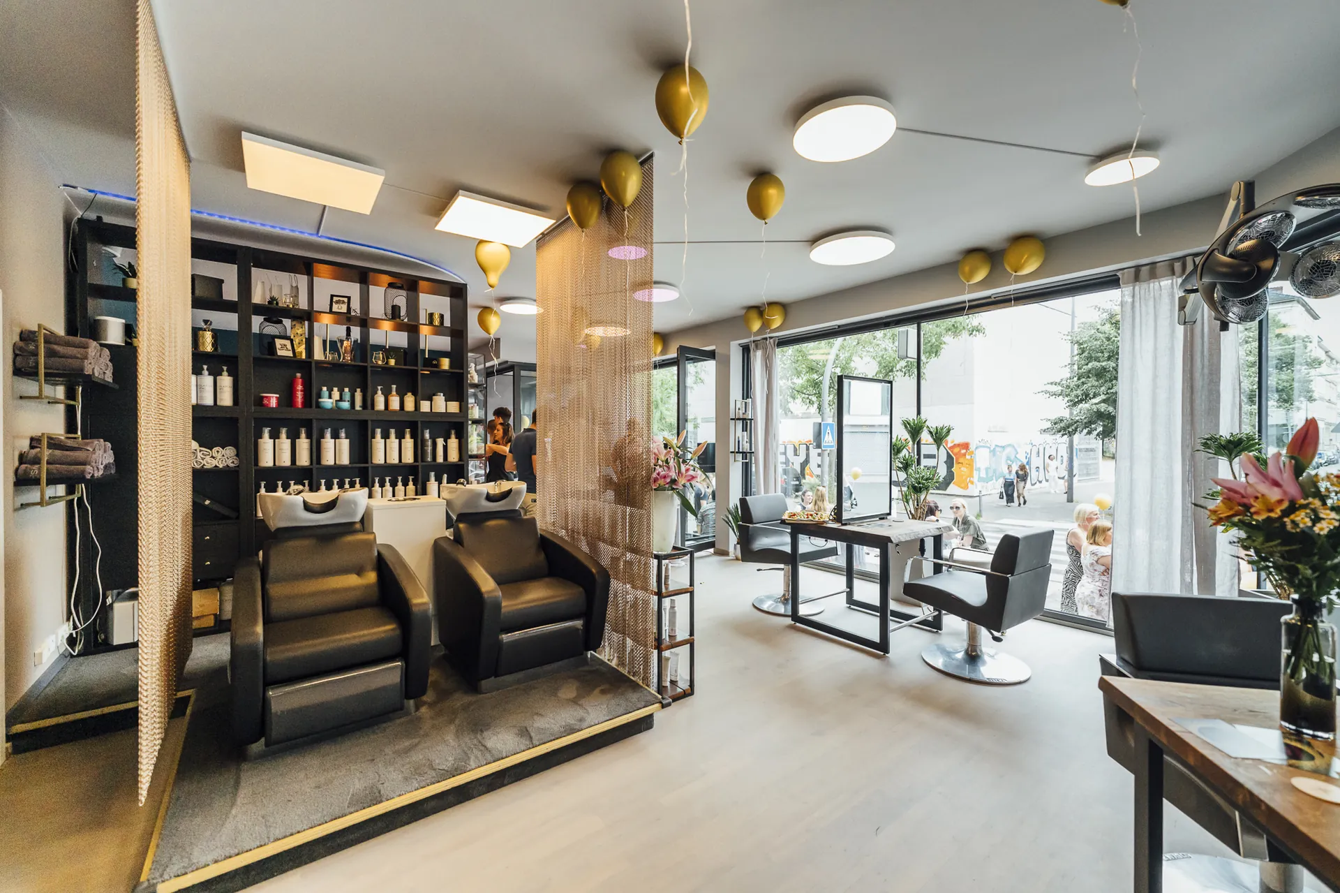 Hairspa-Bereich mit schwarzen Waschsesseln und Produktwand